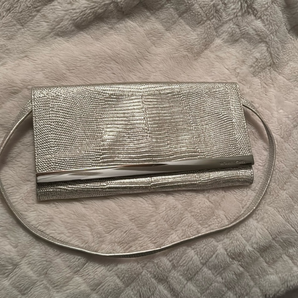 Michael kors silver metallic clutch with strap.